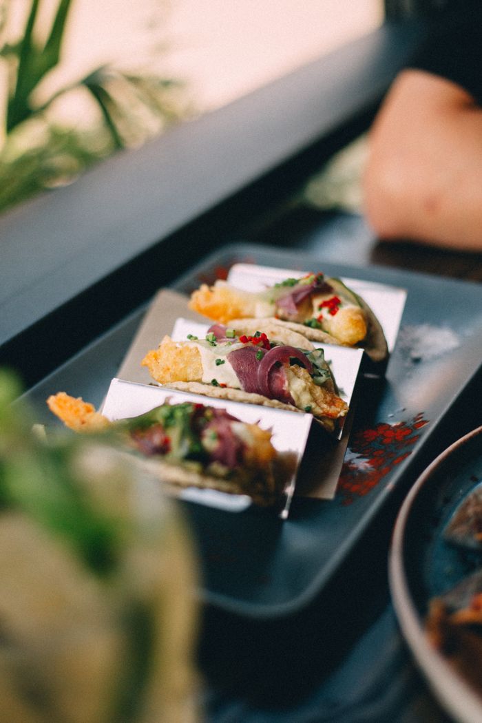 Mouthwatering tacos served on a sleek black plate, perfect for a gourmet meal.